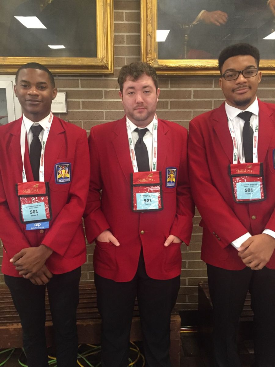 Young African American college students Joseph Currington(left), Jaeden Felder(right) and young Caucasian college student Charles Spruill(center) pose for a photo in red sports jackets and white dress shirts.