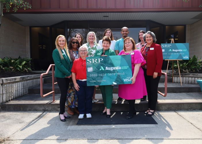 SRP Credit Union representatives stand with Augusta Technical College representatives holding an example of the new debit card.