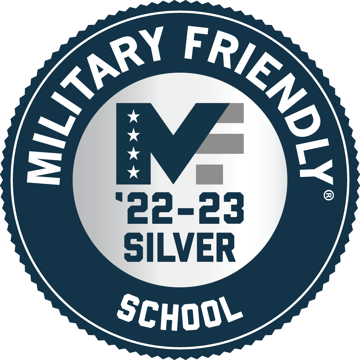 2022-2023 Military Friendly School Silver logo - A blue multi-pointed award circle with a white circular outline close to the outside edge. The words Military Friendly circle the top half of a silver inner circle with the word School centered at the bottom. MF '22-23 Silver is in three stacked horizontal rows centered on the inner silver circle with the M's right leg composed of the F's leg. The M is navy blue with four white stars in a vertical line on the left leg. The F is composed of three grey lines broken by three white lines. '22-23 Silver is in navy blue font as well.