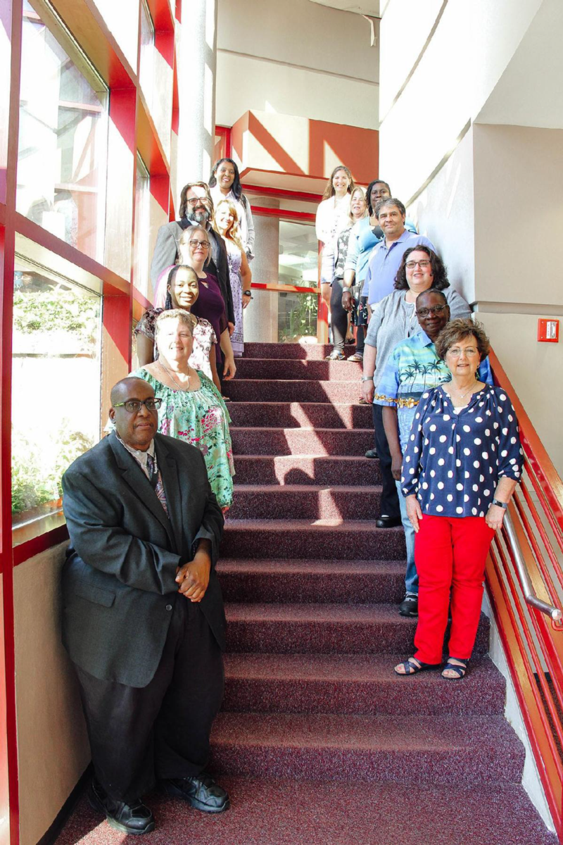 Group of people standing on stairs posing for a photo.