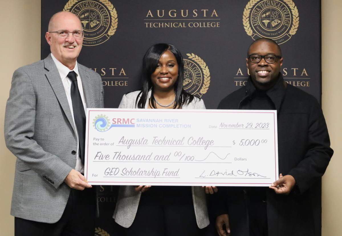 SRMC President and Program Manager Dave Olson, Dean of Adult Education Angela Moseley, and Augusta Tech President Jermaine Whirl stand holding a check for five thousand dollars.
