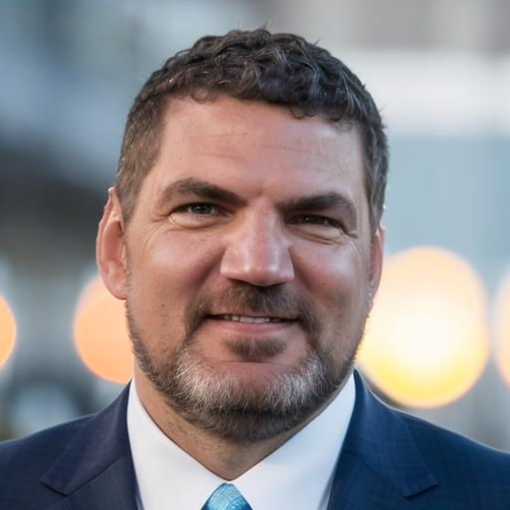 Peter Claus, Caucasian male smiling wearing a blue suit.