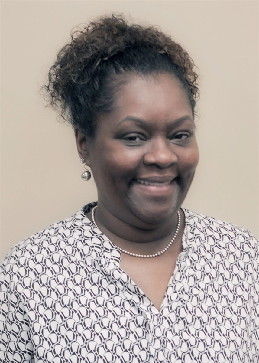 Ms. Alberta Mobley, an African American female, smiles at the camera wearing a patterned blouse and pearl necklace.