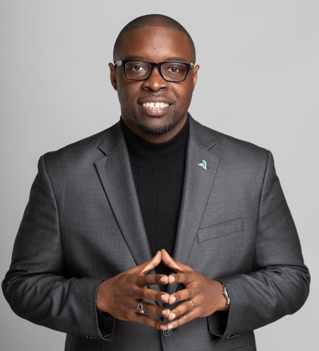 Dr. Jermaine Whirl wearing a black sweater with a silver gray suit jacket and the Augusta Technical College logo pin on his left lapel.