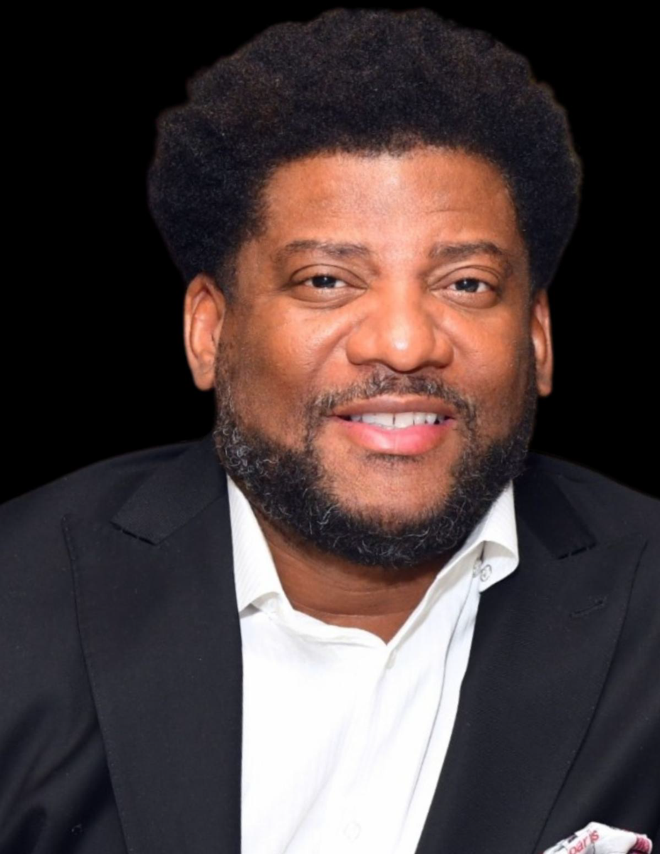 Mr. Malcolm Cunningham, an African American male and owner of Malcolm Cunningham Automotive Group, Inc, smiles wearing a black suit jacket and white collared shirt.